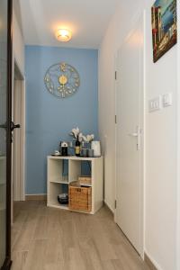 un corridoio con una parete blu e un orologio sul muro di Porto Azzurro apartments a Tivat