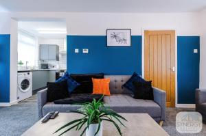 sala de estar con sofá y pared azul en Pacific House, Manchester - by Synergy Estates en Mánchester