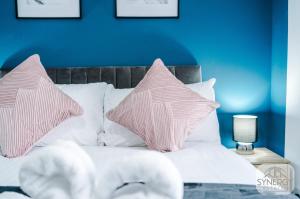 a bed with pink and white pillows on it at Pacific House, Manchester - by Synergy Estates in Manchester