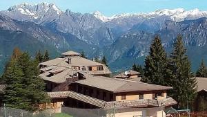 een groot huis met bergen op de achtergrond bij Rifugio di Losine - Relax - Natura - Wi-Fi in Esine