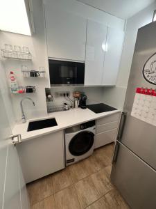 a white kitchen with a sink and a dishwasher at Green terrace aircondition downtown metro C Budějovická in Prague