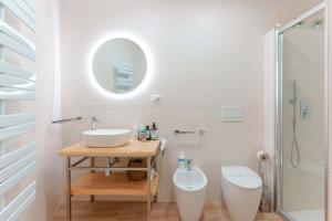 a bathroom with a sink and a toilet and a mirror at Montellino's Suite Oro in SantʼAntìoco