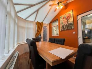 a dining room with a wooden table and black chairs at Chapter Homes Newcastle in Saint Peters