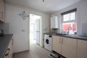 cocina con fregadero y lavadora en Pass the Keys New Dream Home Estate, en Londres