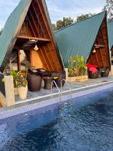 a house with a swimming pool in front of it at Sundown Lake Hotel & Spa in Habarana
