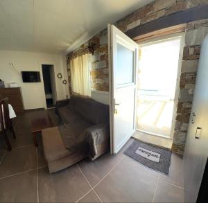a living room with a couch and a stone wall at πετρινη κατοικια in Vári