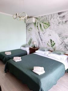 Rooms Sanja, Lovran - Opatija في لوفران: سريرين في غرفة مع لوحة جدارية على الحائط
