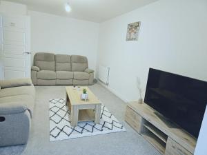 a living room with a flat screen tv and a couch at Orient Oasis Yarm in Yarm