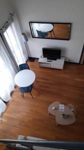 a living room with a table and a tv at triplex, centre-ville, terrasse in Nogent-sur-Marne