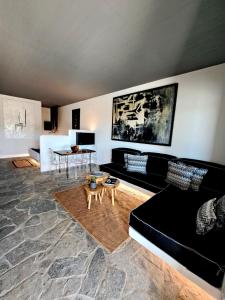 a living room with a black couch and a table at casa mia in Ano Mera