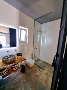 a bathroom with a toilet and a glass shower at casa mia in Ano Mera