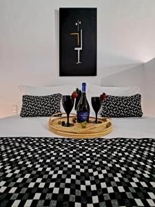 a tray with wine bottles and glasses on a bed at casa mia in Ano Mera