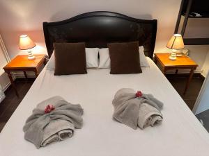 a bed with towels on it with two lamps at πετρινη κατοικια in Vári