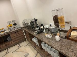 a kitchen with a counter top with a bunch of appliances at Petra Premium Hotel in Wadi Musa