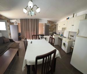 a kitchen and living room with a white table and chairs at πετρινη κατοικια in Vári