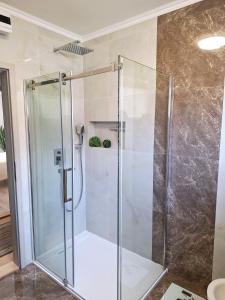 a shower with a glass door in a bathroom at Rooms Sanja, Lovran - Opatija in Lovran