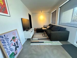 uma sala de estar com um sofá e uma televisão de ecrã plano em Selbraut - Birta Rentals em Reykjavík