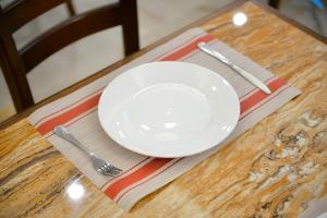 a white plate on a table with a fork and knife at Petra Premium Hotel in Wadi Musa