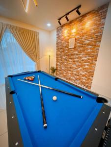 a pool table in a room with a brick wall at 16pax+Ninja's SweetHome Seremban in Seremban