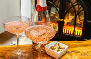 two wine glasses sitting on a table next to a bottle at Central 3 - Bedroom Townhouse in Brighton with Parking in Brighton & Hove
