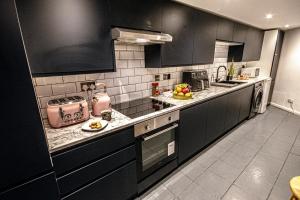 a kitchen with black cabinets and a counter top at Central 3 - Bedroom Townhouse in Brighton with Parking in Brighton & Hove