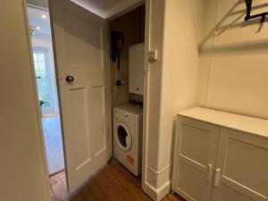 lavadero blanco con lavadora y secadora en 3 Bed luxury house, 10 min walk to underground en Londres