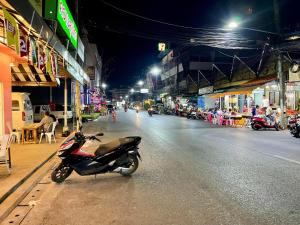 una moto estacionada en el lado de una calle por la noche en Lamoon 90s en Hat Yai