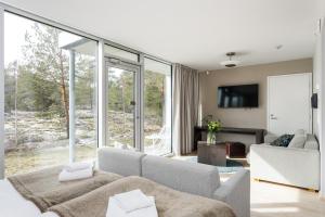 a living room with white furniture and a large window at Kultaranta Resort in Naantali