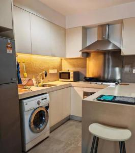 a kitchen with a washing machine and a stove at 2Rooms QueenBed In D Heart of KL in Kuala Lumpur