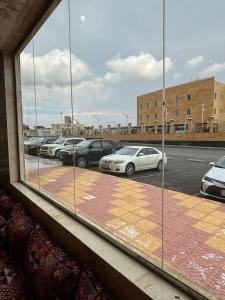a view of a parking lot from a window at قصر نوماس للشقق المخدومة الواديين in Al Wadeen