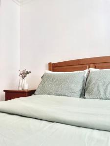 a bed with white sheets and blue pillows at Sabugal Comfort - Central Castelo in Sabugal +14 photos