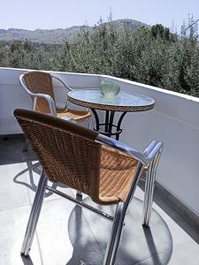 una mesa y sillas sentadas en un balcón en Paradise Apartment, Lardos Village, en Lardos