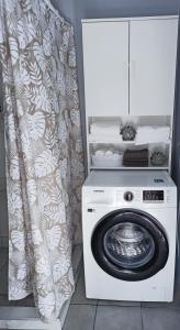 uma máquina de lavar roupa branca num quarto com uma cortina em Lardos Apartment em Lardos