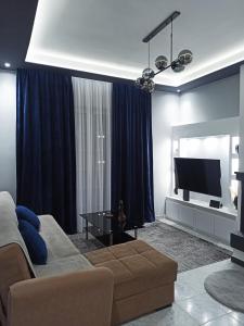 uma sala de estar com um sofá e uma televisão de ecrã plano em Lardos Apartment em Lardos
