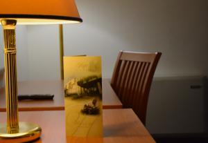 uma secretária com um candeeiro e uma cadeira ao lado de uma secretária com uma fotografia em Hotel 90 em Capurso