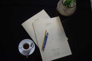 una scrivania con una tazza di caffè, una penna e dei giornali di Hotel 90 a Capurso