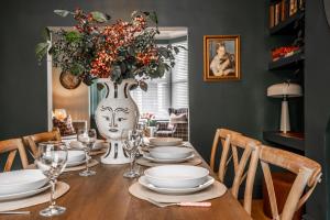 a dining room table with a vase filled with flowers at Arkles - Victorian Gem in Liverpool