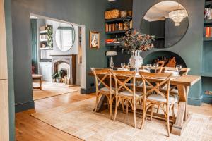 una sala da pranzo con tavolo, sedie e camino di Arkles - Victorian Gem a Liverpool