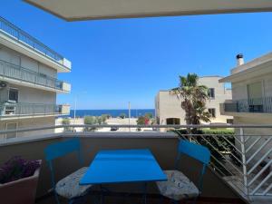 patio con mesa azul y sillas en el balcón en CASA SARADO, en Polignano a Mare