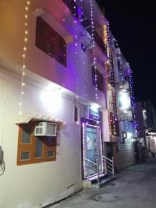 a white building with a window and a door with lights at Hotel Gayatri Guest House Haridwar Near Railway Station - Ganga Ghat - Best Hotel in Haridwar in Haridwār