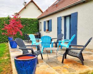 een groep stoelen en tafels op een patio bij Le Cissereau - Chambres et table d'hôtes in Onzain