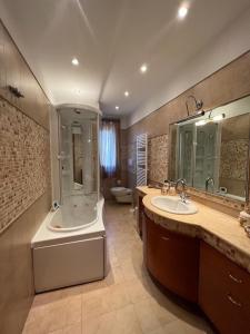 y baño con 2 lavabos, bañera y ducha. en CASA SARADO, en Polignano a Mare