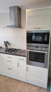 a kitchen with white cabinets and a stove top oven at The Crescent in Brixton