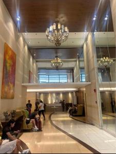 um lobby com pessoas sentadas em cadeiras em um edifício em Grand Riviera Suites em Manila
