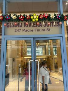 a woman is standing in front of a store at Grand Riviera Suites in Manila