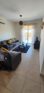 ein Wohnzimmer mit einem Sofa und einem Tisch in der Unterkunft Kapparis Apartment Mythical Sands in Protaras