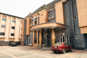 a red car parked in front of a building at Diamond Castle Hotel in Owerri
