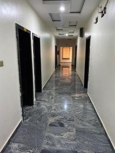 einen leeren Flur mit Türen und Fliesenboden in der Unterkunft Diamond Castle Hotel in Owerri