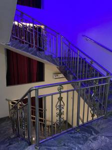 una escalera de caracol en una habitación con iluminación púrpura en Diamond Castle Hotel, en Owerri