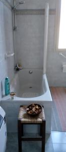 a bathroom with a bath tub with a bowl on a stool at Il forno in Cossogno